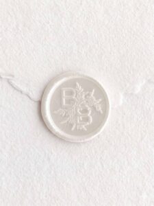 Sello de lacre Blanco Mate con iniciales sobre papel artesanal blanco