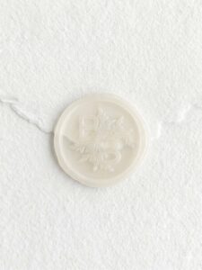Sello de lacre transparente Velo con iniciales sobre papel artesanal blanco