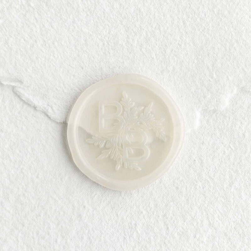 Sello de lacre transparente Velo con iniciales sobre papel artesanal blanco
