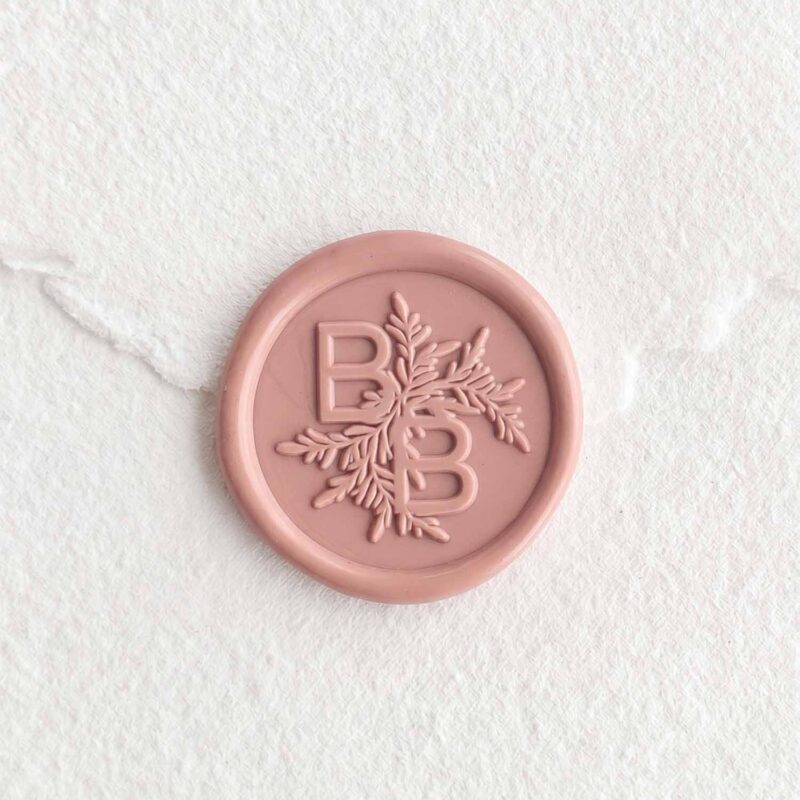 Sello de lacre Rosa Viejo con iniciales sobre papel artesanal blanco