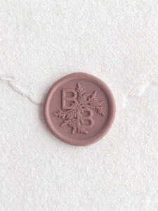 Sigillo in ceralacca Terra Malva con iniziali su carta artigianale bianca