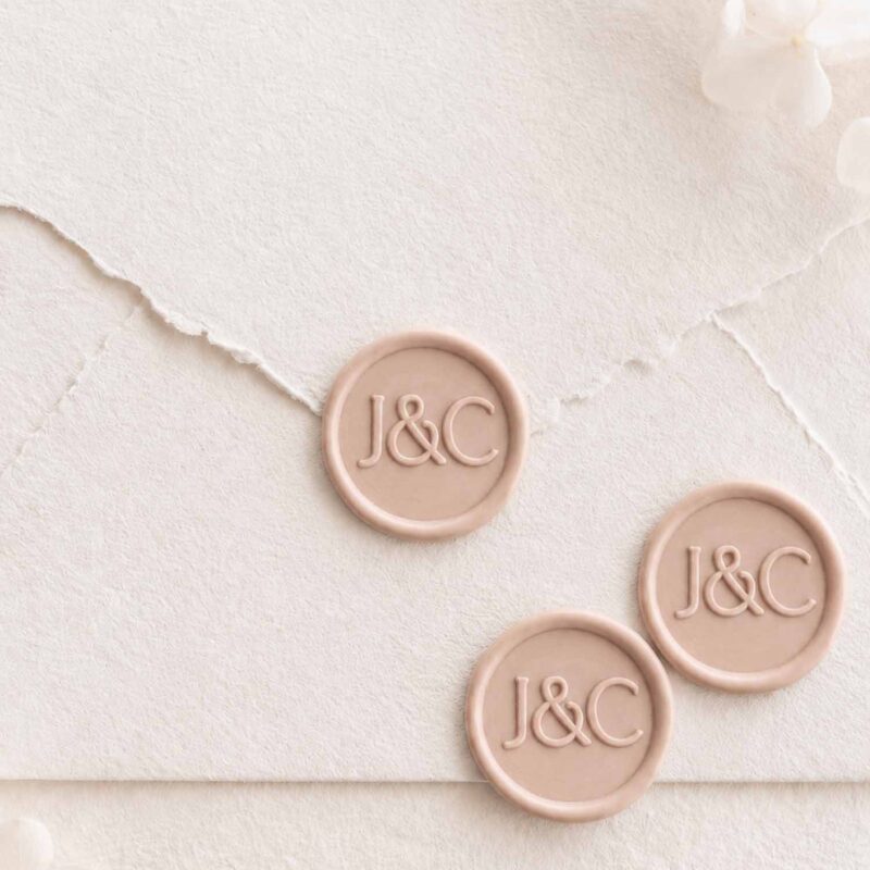 Sello de lacre adhesivo personalizado Clara con iniciales sobre sobre artesanal para invitaciones de boda.