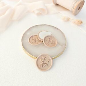 Sello de lacre adhesivo personalizado con monograma Adriana sobre sobre artesanal para invitaciones de boda.