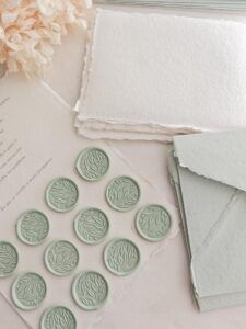 Sellos de lacre adhesivos verde matcha con diseño botánico sobre papel artesanal