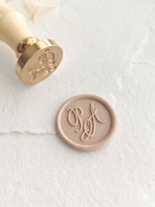 Detalle de sello de lacre personalizado con iniciales en cursiva elegante