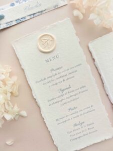 Menú de boda en papel artesanal color marfil con sello de lacre botánico de la colección Chloé.