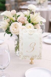 Número de mesa Adriana en papel artesanal marfil con lacre personalizado y estampado floral beige.