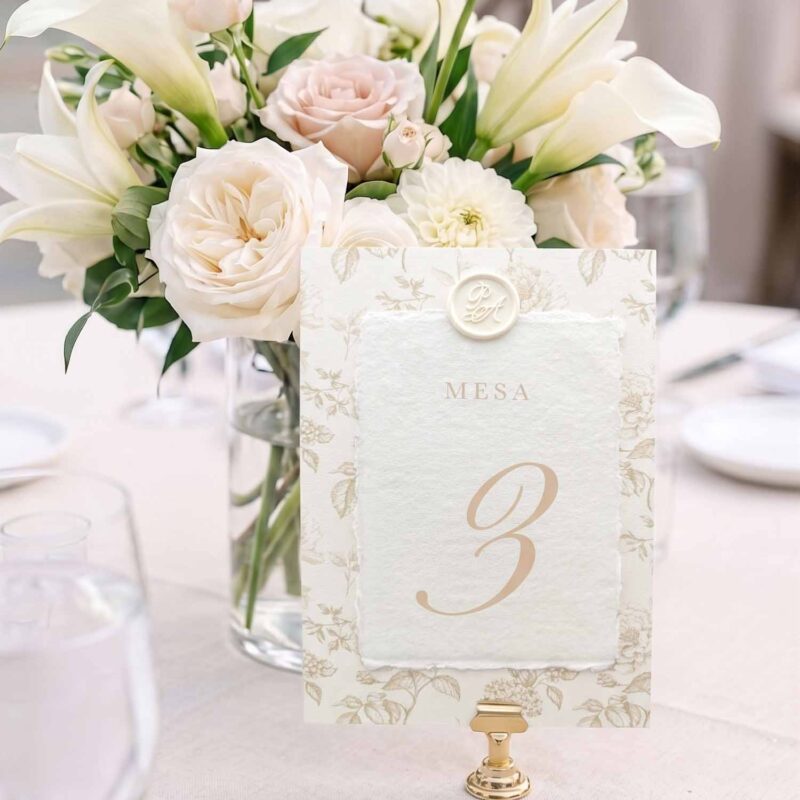 Número de mesa Adriana en papel artesanal marfil con lacre personalizado y estampado floral beige.