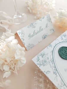 Puesto de mesa Elodie con nombre del invitado impreso y diseño botánico verde salvia.