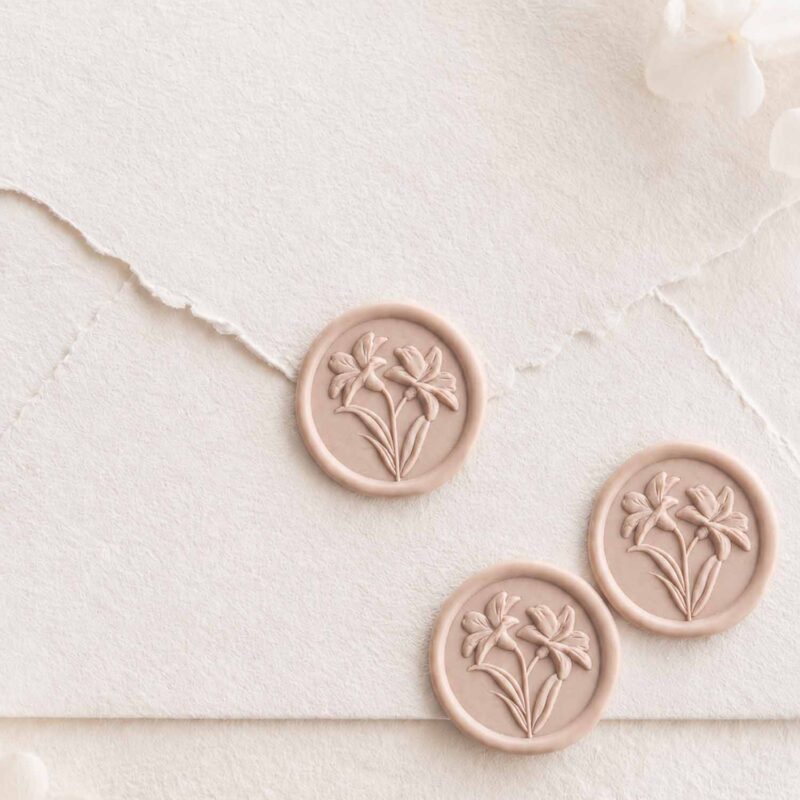 Sellos de lacre adhesivos con diseño de lirios en relieve 3D sobre sobre artesanal para invitaciones de boda.