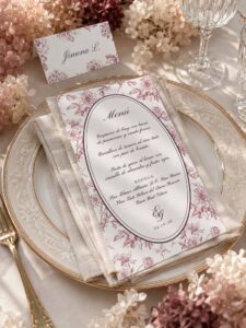 Menú de boda Elodie Burdeos en papel verjurado sobre servilleta de lino y vajilla clásica.